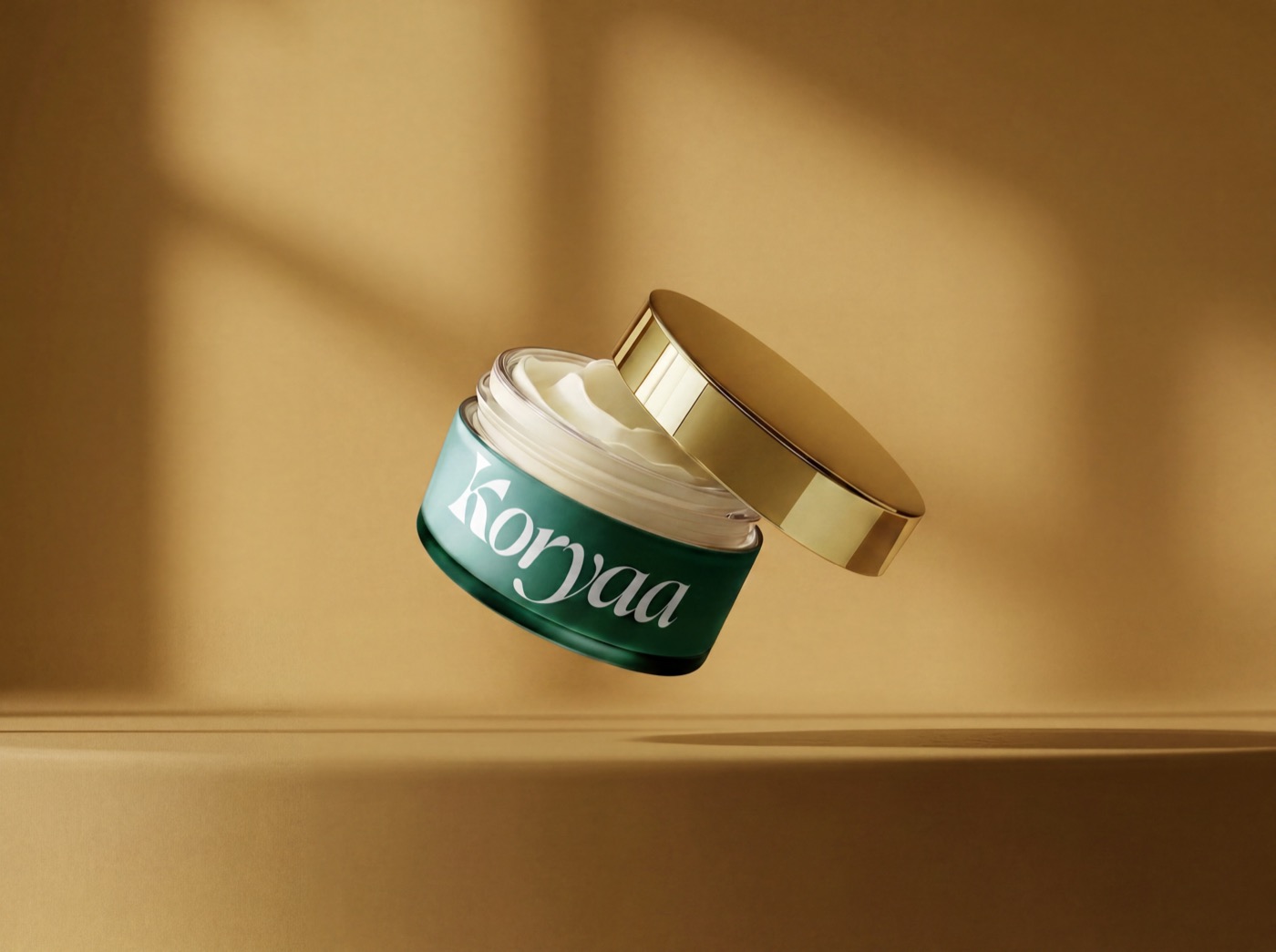 Packaging Koryaa : pot de crème vert et or avec wordmark, mise en situation lumière chaude